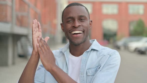 Outdoor Portrait of Happy African Man Clapping Applauding alt