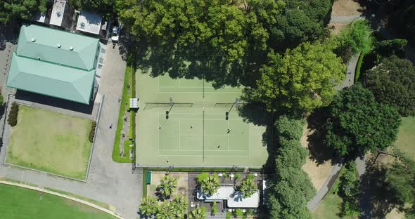 Static aerial shot looking directly down on tennis court as people play. alt
