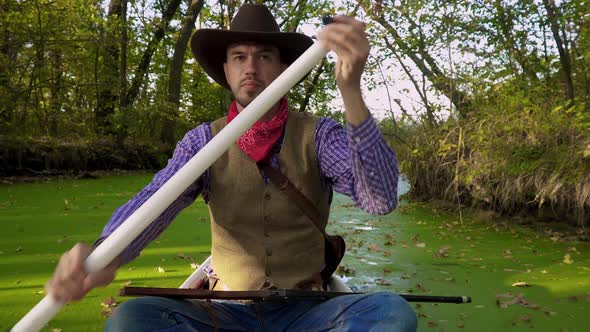 Cowboy in a Canoe Floats on the River alt