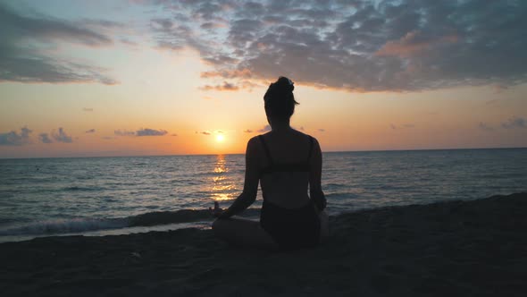 Young Woman Meditating Near The Sea