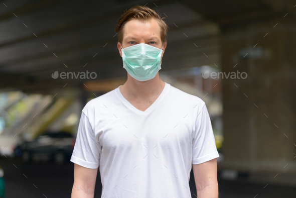 Young man wearing mask in the city streets for protection from corona virus outbreak