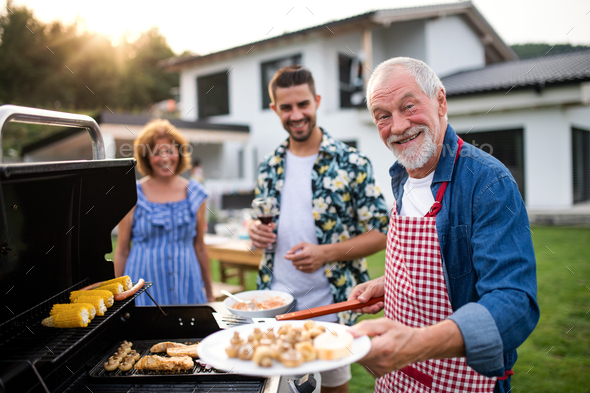 Portrait of multigeneration family outdoors on garden barbecue, grilling