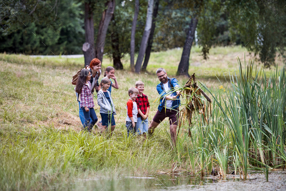 Group of school children with teacher on field trip in nature