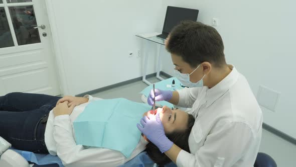 Dentist treating his patient alt