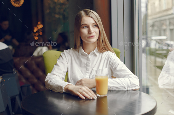 Elegant woman in a white blouse spend time in a cafe