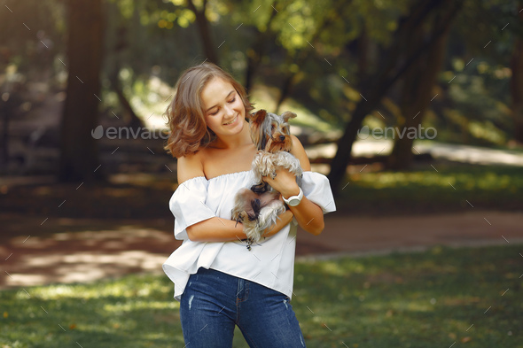 Cute girl in white blouse playing with little dog