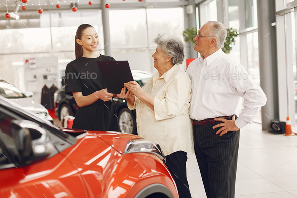 Stylish and elegant old couple in a car salon