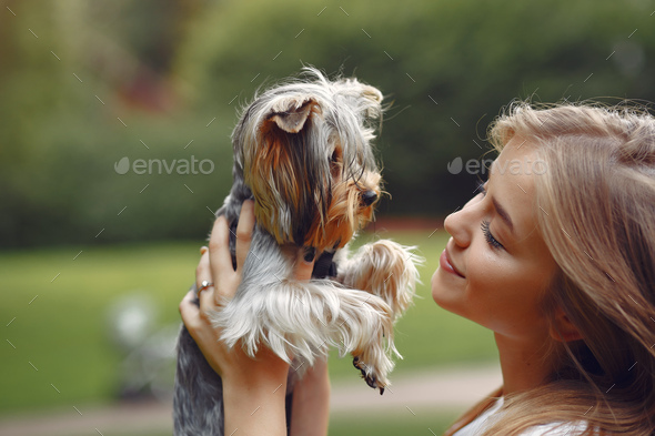 Cute girl in white blouse playing with little dog