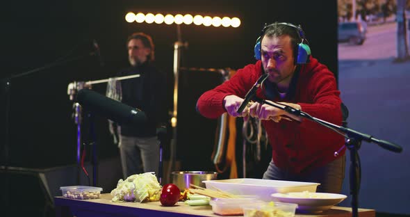 Man Breaking Dry Pasta for Movie Soundtrack alt