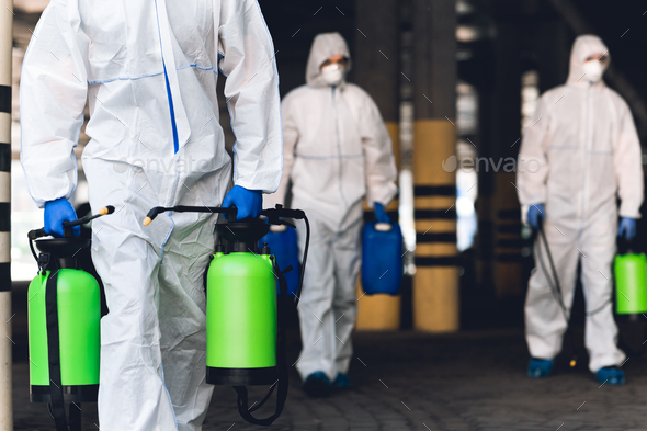 Men in virus protective suits carrying spray bottles with chemicals