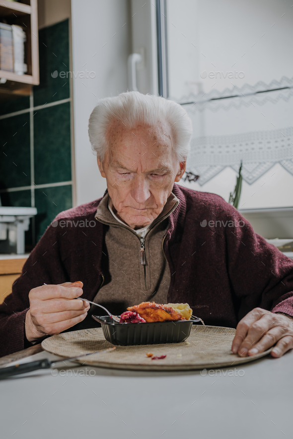 Single senior eats dinner at home - Stock Photo - Images