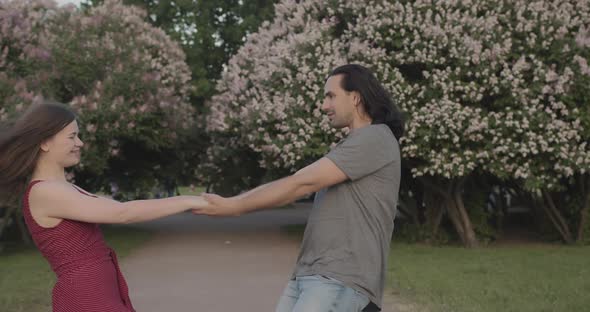 Young Enamored Friends Hugging and Circling in the Park in Slow Motion alt