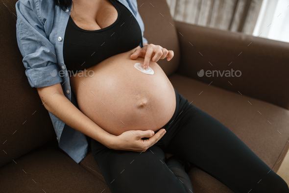Pregnant woman with belly relaxing on couch
