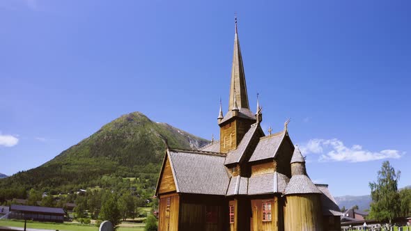 Exterior View Of Stave Church With Gravestone On A Sunny Summer Day In Norway. - aerial ascend alt