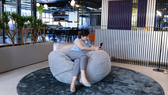 Asian woman using her phone in a bean bag