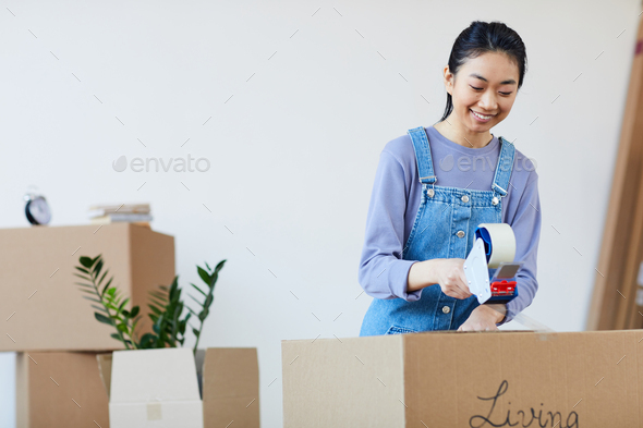 Young Asian Woman Packing Boxes for Moving
