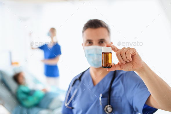 Doctor holding medication cure in hospital, coronavirus concept