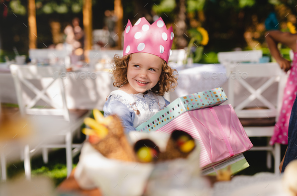 Small Girl Outdoors In Garden In Summer, Holding Presents Stock Photo 