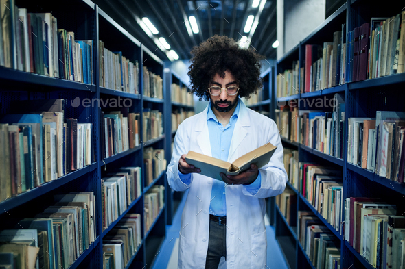 Doctor standing in library, studying information about corona virus