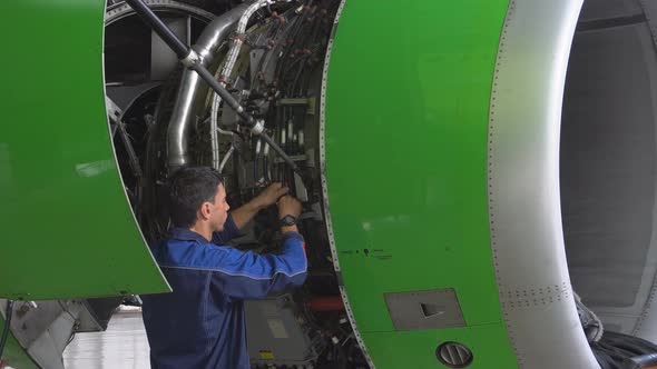 Engine Passenger Aircraft Maintenance. Engineer Checks the Engine of the Aircraft alt