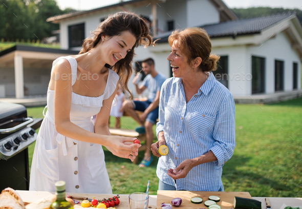 Portrait of multigeneration family outdoors on garden barbecue, grilling