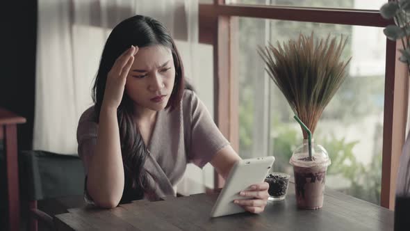 stressed woman having credit card problem to shopping online with tablet at the café