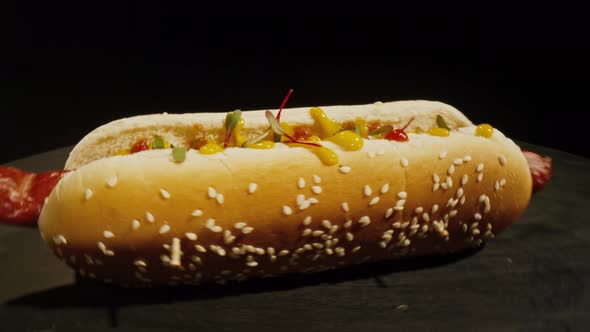 Camera Revolves Around a Hot Dog in a Bun of Sesame and Sausage