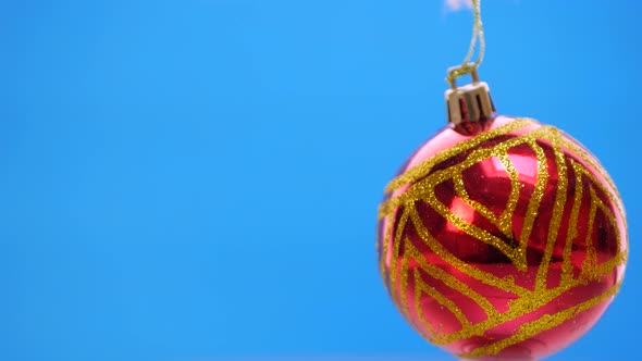 Decorated Red Christmas Balls Spinning on Blue Background