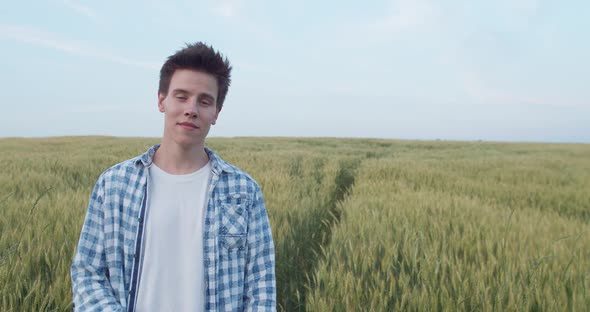Portrait of Boy Looking at Camera and Crossing Hands with Smile in Field alt