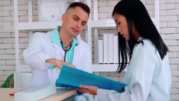 Doctor in Professional Uniform Examining Patient at Hospital alt