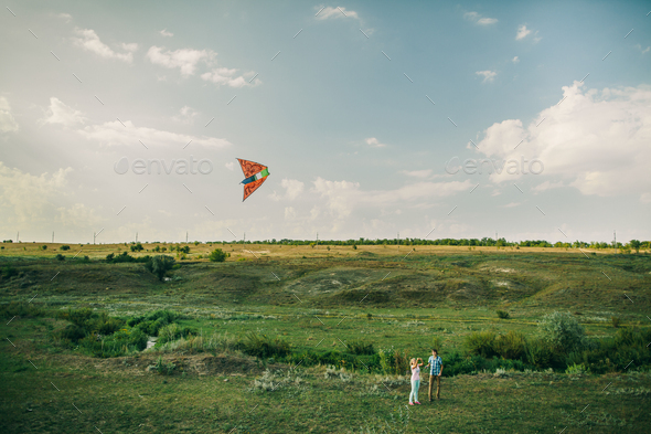 couple play with air kite at green meadow