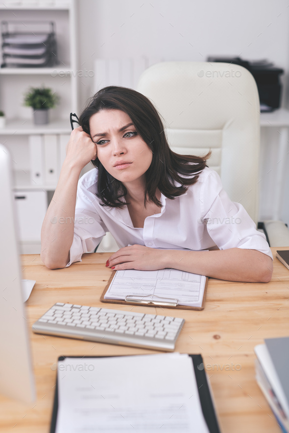Young tired or annoyed businesswoman waiting for online page uploading