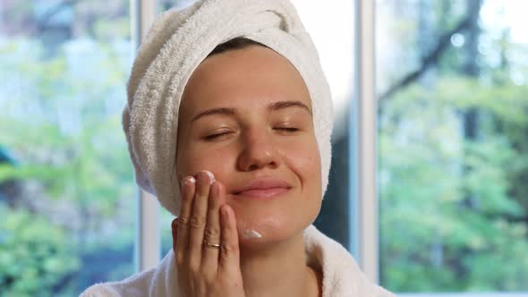 Young Woman Applying Facial Moisturizer