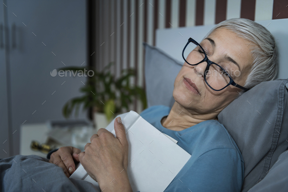 Sleep. Senior Woman Falling Asleep with a Glasses on and a Book on her Chest