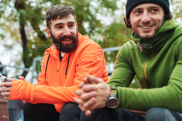Two fit young sportsmen resting after work out outdoors