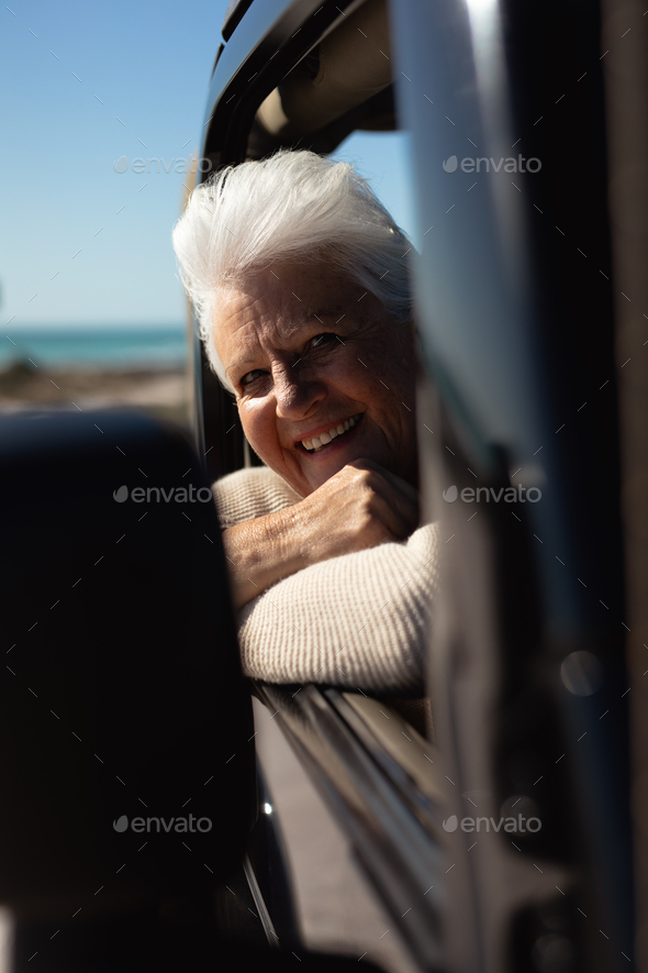 Old woman in a car at the beach