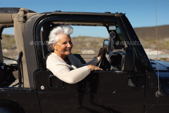 Old woman in a car at the beach