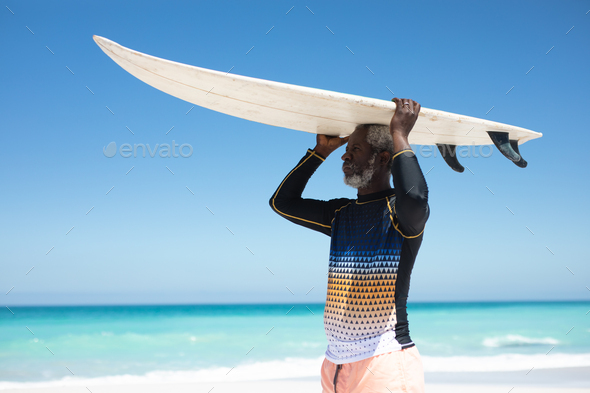 Old man carrying a surfboard