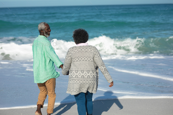 Old couple walking at the beach