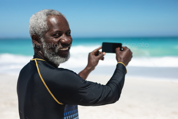 Old man taking pictures of the beach