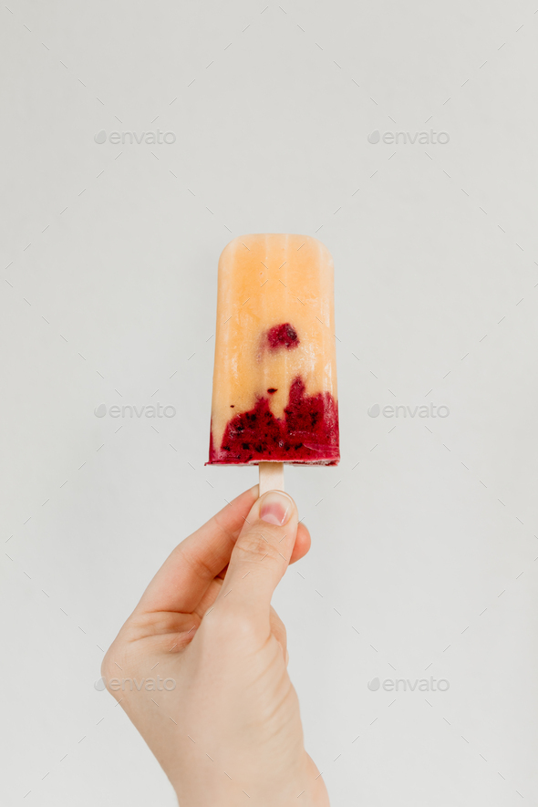 Fruit homemade popsicle made is from fresh mango, blackcurrant and coconut milk.