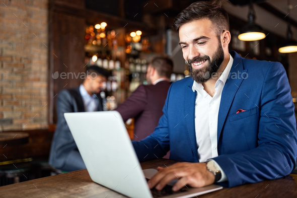 Handsome business man using laptop at his work break in restaurant
