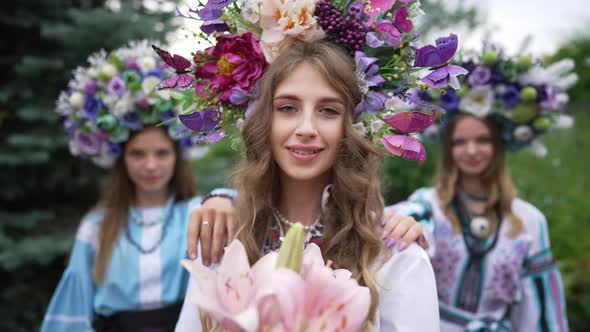 Brunette Ukrainian Woman with Grey Eyes Looking at Camera Smiling As Friends Touching Shoulders with alt
