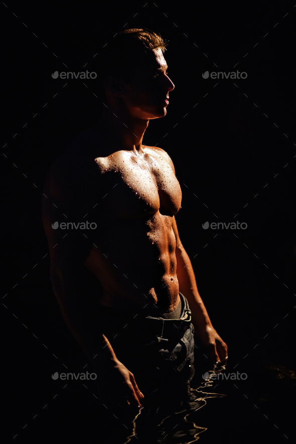 Handsome wet muscular man shirtless wearing jeans silhouette