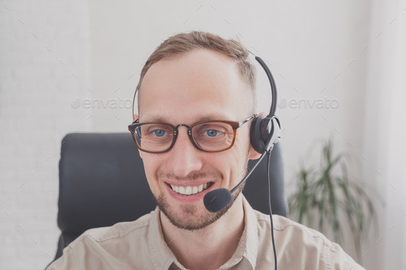 Young man with headset for online communication. Support or customer service worker - Stock Photo - Images