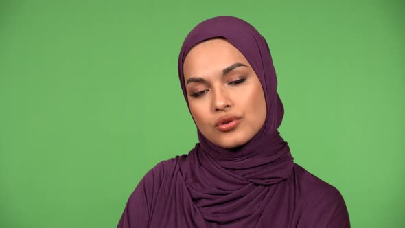 A Young Beautiful Muslim Woman Talks to the Camera  Closeup  Green Screen Background