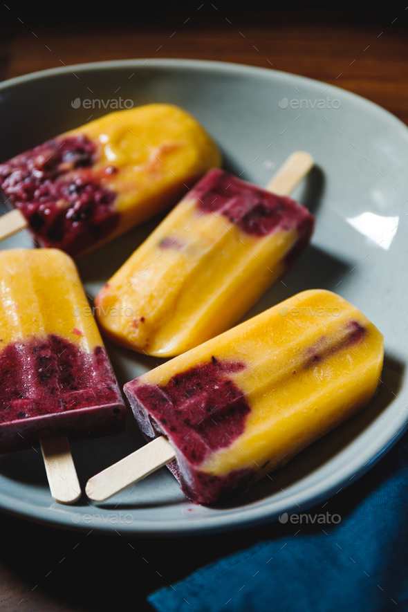 Fruit homemade popsicles made are from fresh mango, blackcurrant and coconut milk