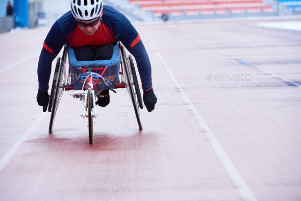 Determined athlete in sportswear and helmet participating in wheelchair race