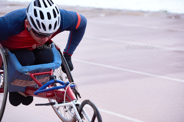 Determined handicapped male athlete in helmet racing in specialized handcycle