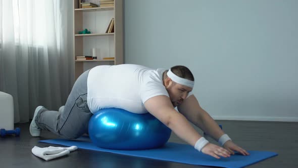 Plump Male Doing Static Exercise Effort on Fitness Ball, Desire to Lose Weight alt